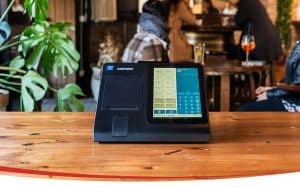 Uno dei registratori telematici con POS integrato realizzato da Custom si trova sul bancone di un locale.